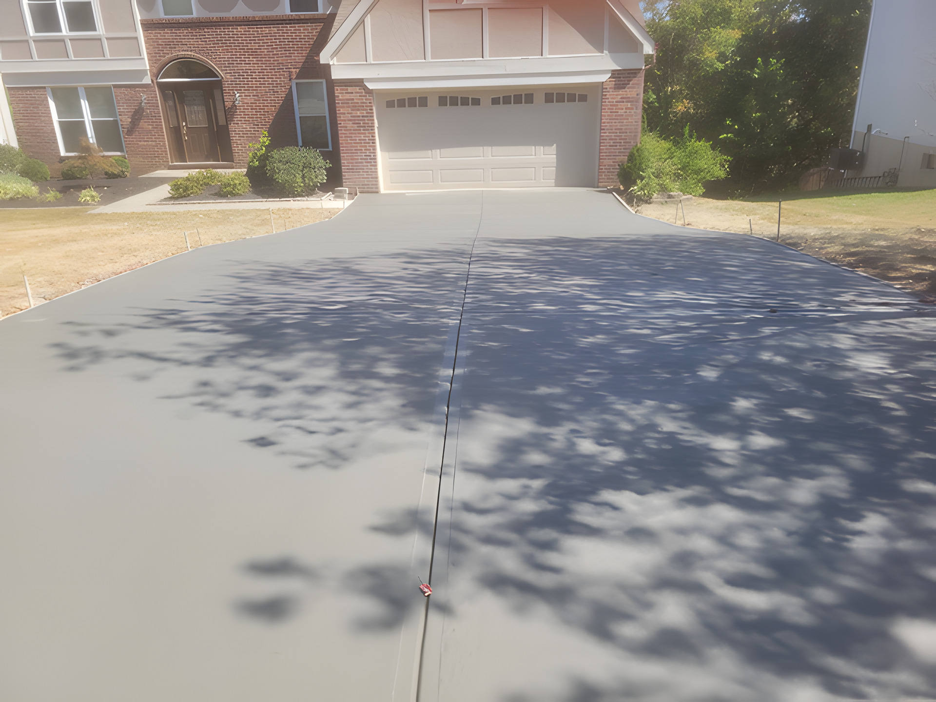 Large residential concrete driveway installed by Affinity Utilities, finished out to the garage apron
