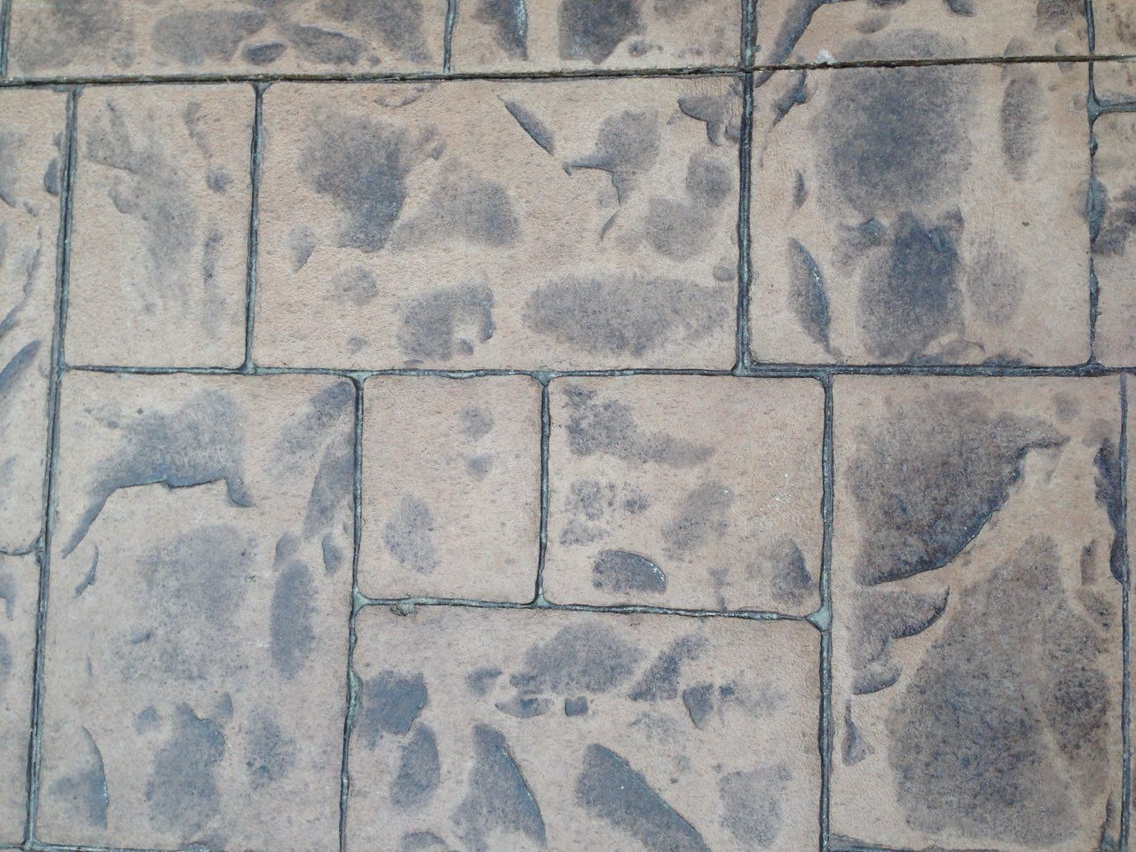 Close-up of stamped concrete showing an ashlar slate pattern with color variation