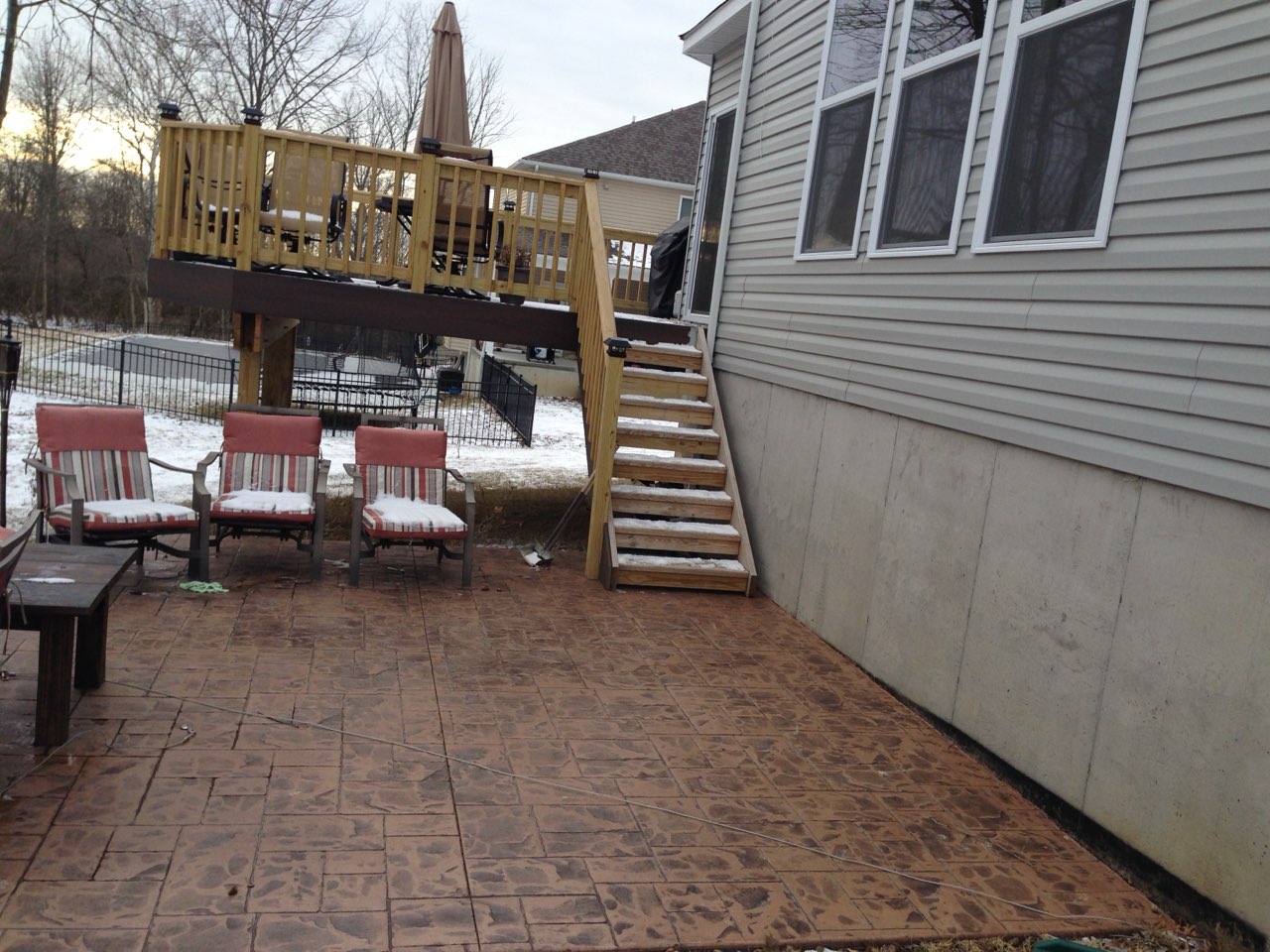 Stamped concrete patio with a stone pattern installed beneath a residential deck